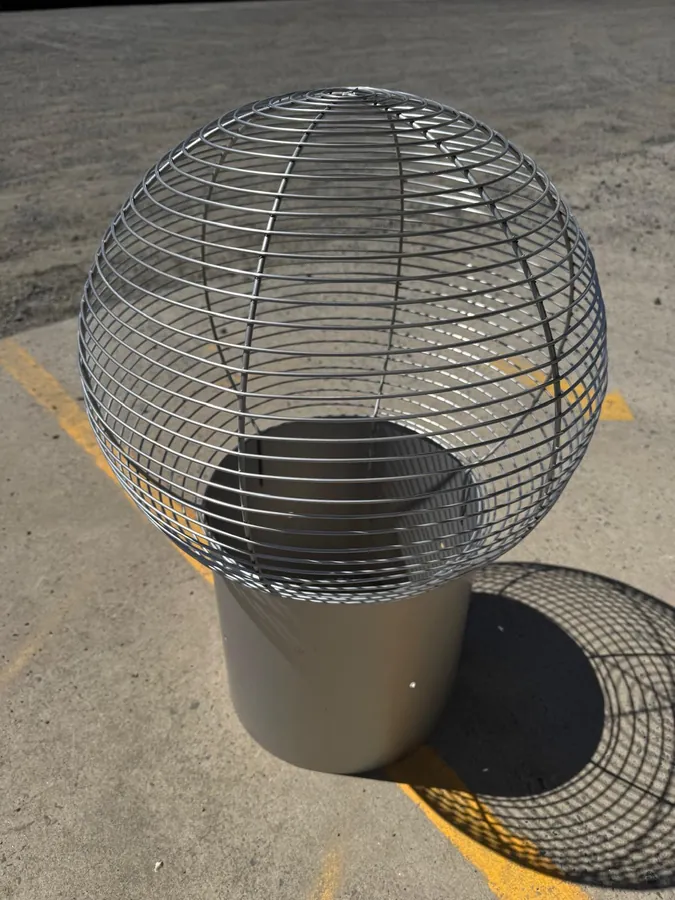 Stainless steel wire (bird) cowl fitted to a short vent pipe section, in a yard